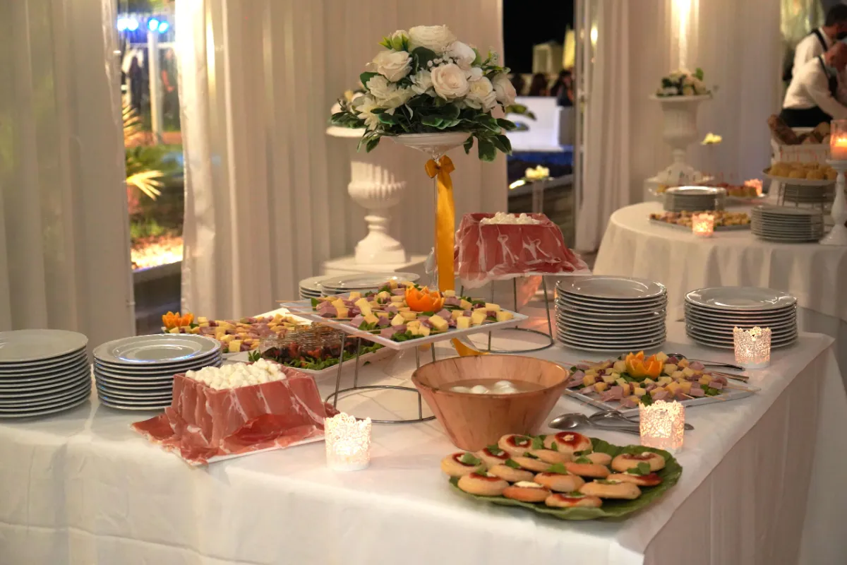 Buffet allestito in sala con composizioni floreali